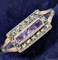 Close-up photo of the ring face showing four square amethyst stones surrounded by marcasite stones on a silver setting.
