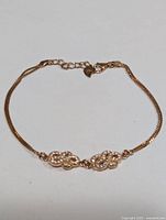 Silver cubic zirconia bracelet laid flat, showing delicate chain and linked ornamental sections.