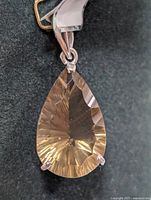 Close-up front view of the pear-shaped faceted smokey quartz gemstone in a silver pendant setting.