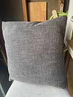 Front view of gray fabric throw pillow showing textured solid color pattern