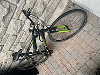 Side view showing black and green frame, medium size, and 21-speed gear system.