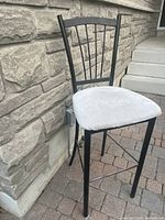 Full view of the stool showing metal frame, fabric seat, and slat backrest design.