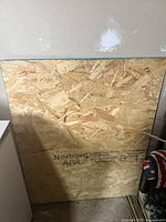 Front view of one Norbord plywood sheet with APA rating and dimension markings visible.