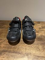Front view of Peloton cycling shoes showing the black synthetic upper, velcro and buckle closure system, and size 43 fit for men.