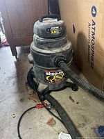 Shop-Vac QSP vacuum showing tank with attached hose, power cord, and visible dirt and wear.