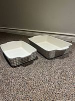Two ceramic baking dishes on carpet floor; one with grid pattern and one with polka dots, shown side by side.