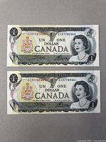 Two sequential $1 Canadian banknotes laid flat, showing front side with portrait of Queen Elizabeth II, bilingual text, and coat of arms, clear detail of serial numbers.