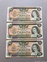 Front view of three Canadian 1979 series $20 bills stacked, showing Queen Elizabeth II portrait and Canadian coat of arms.