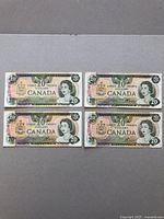 Four Canadian $20 bank notes from 1979 shown front side, featuring Queen Elizabeth II portrait and the Canadian coat of arms.