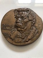 Front view of bronze medallion showing Dr. Albert Schweitzer's bust with engraved signature and date.
