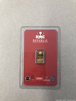 Front view of sealed red assay card with gold bar centered beneath RMC Republic Metals Corporation logo