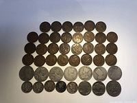 Top-down view of 46 coins laid out on a white surface showing Canadian and American quarters, dimes, nickels, and pennies with varied designs.