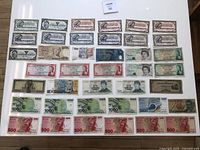 Photo showing multiple rows of Canadian Tire money in various denominations and colors along with international banknotes from different countries arranged on a floor.
