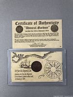 Front side showing the Certificate of Authenticity and the shipwreck coin in protective casing with historic illustrations.