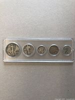 Five vintage American coins in a clear protective case laid flat against a neutral background.