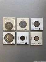 Six Canadian coins in protective holders shown arranged on a surface, annotated by year and prices.