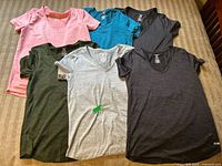 Six Athletic Works women's dry-more tech T-shirts laid flat in various colors showing full fronts.
