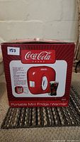 Box front showing the Coca-Cola branded portable mini fridge/warmer with product image and capacity details.