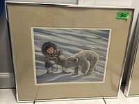 Framed ink print of Inuit child near polar bear in snowy setting