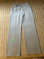 Full view of the grey Lululemon Softstreme pants laid flat on a striped surface, showing their overall length, shape, and elastic waistband.