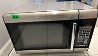Front view of Cuisinart microwave showing stainless steel exterior with door window and handle.