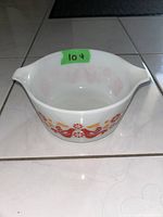 Top and side view of the white milk glass casserole dish with orange and red Friendship pattern, showing shape and design detail.