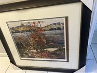 Framed print of 'Red Tree by the Lake' showing the scene and frame with protective corner covers.