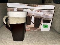 One mug displayed upright alongside the original box showing the product image, highlighting its size, shape, and dual-tone reactive glaze finish.