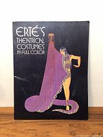 Front cover of the art book titled 'Erte's Theatrical Costumes in Full Color' showing an illustration of a costume in purple and gold.