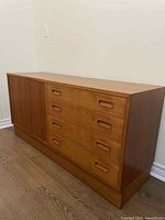 Full front perspective of the teak sideboard showing four drawers on right and sliding cabinet doors on left