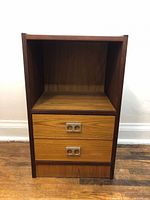 Front view of the Mid Century Modern teak veneer nightstand showing two drawers with distinctive metal handles and open compartment.