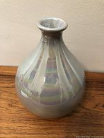 Front angle view of one pearlescent vase showing bulbous body and narrow neck