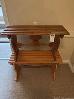 Two wooden slatted benches stacked together against a wall with visible electrical outlet.