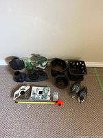 Various ceramic candle holders, flower pots, and two wooden bird figurines arranged on carpet