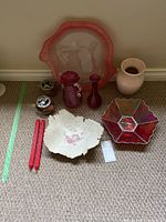 Display of all decorative items including glass trays, vases, ceramic bowls, and candles laid on carpet showing various colors and shapes.