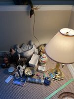 Overview of assorted household decor items and brass table lamp, detailing the variety of materials and styles in the lot.