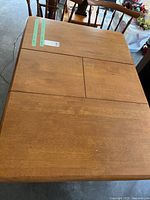 Top view of the rectangular wooden kitchen table showing the leaf extension in center and warm brown wood finish.