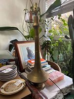 Full view of the brass tall lamp surrounded by other household items.