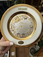 Front view of the 24k gold-rimmed anniversary plate showing 'Happy 50th Anniversary' text and floral designs.