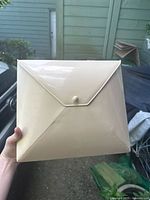 Front view of the beige envelope organizer with flap closed and snap button secured.
