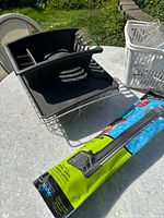 Photo of stainless steel and black plastic kitchen dish rack placed on outdoor table.