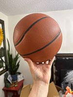 Close-up of a brown basketball with black grooves, showing textured surface.