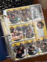 Page of hockey cards in plastic sleeves inside the collector's binder featuring multiple players.