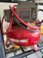 Overall view of Porter-Cable red pancake air compressor with hose