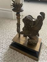 Oblique view of brass winged lion lamp showing figure, torch column and base