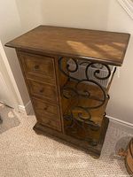Front view showing drawers, iron scrollwork, top and base
