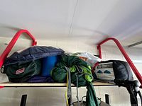 Packed tents and sleeping bags on shelf