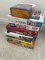 Stack of seven boxed puzzles showing brands, piece counts and packaging