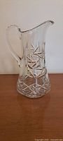 Front side view of the crystal pitcher showing the detailed starburst and geometric cut patterns.