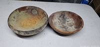 Top view of two wooden bowls side by side showing interior wear and discoloration